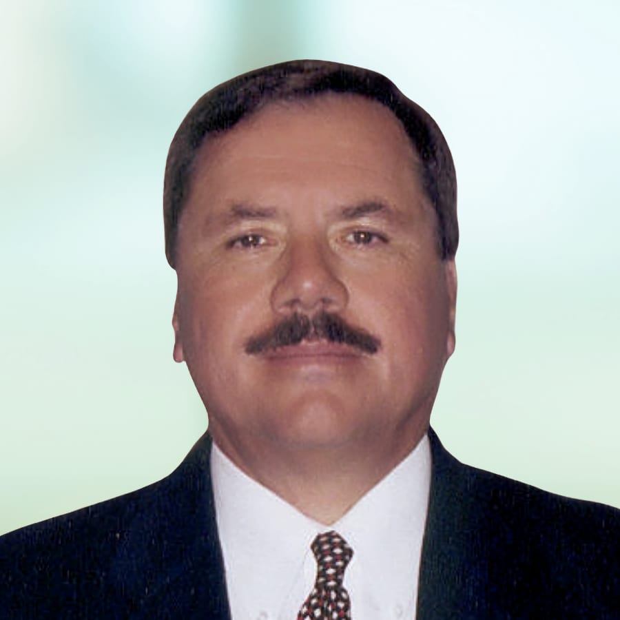 Executive Greg Ashton, man with short brown hair and trimmed mustache wearing a suit